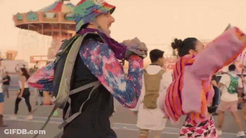 Man With Backpack Dancing At Amusement Park GIF