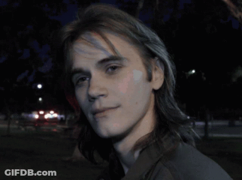 Man With Backpack In Front Of Brick Wall GIF