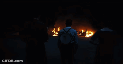 Man With Backpack In Front Of Fire GIF