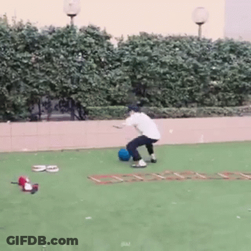 Man With Backpack Jumping Over Water Near Graffiti Building GIF