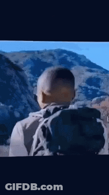 Man With Backpack Standing In Front Of Mountain GIF