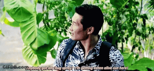 Man With Backpack Standing In Front Of Tree Talking GIF