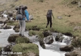 Man With Backpack Walking Across River GIF