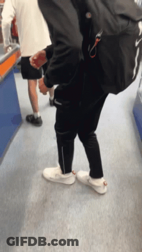 Man With Backpack Walking Down Carpeted Hallway GIF