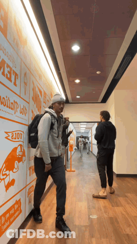 Man With Backpack Walking Past Home Wall GIF