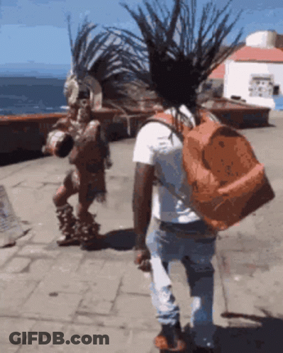 Man With Backpack Walking Past Native American GIF