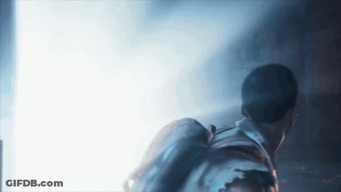 Man With Backpack Walking Through Dark Room GIF
