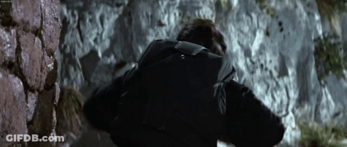 Man With Backpack Walking Up Rocky Hill GIF