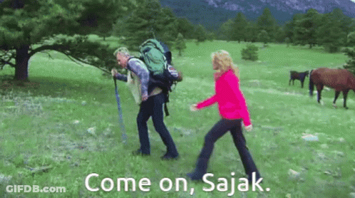 Man With Backpack Walking With Woman In Field With Horses GIF