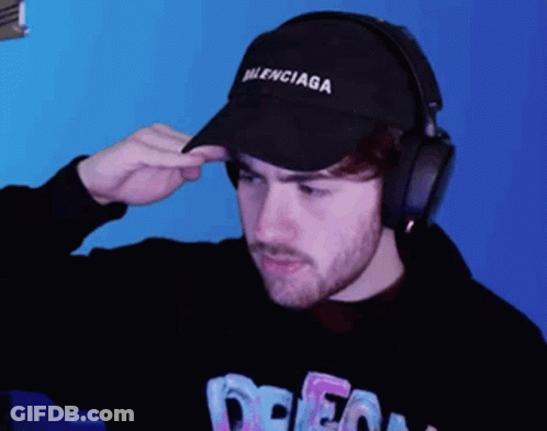 Man With Balenciaga Hat And Headphones Looks At Camera GIF