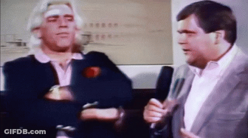 Man With Bandage Talking To Man With Microphone GIF