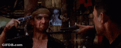Man With Bandana Pointing Gun At Another Man GIF