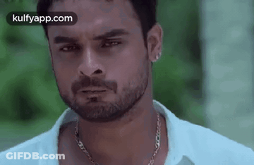 Man With Beard And Chain Necklace Looking At Camera GIF