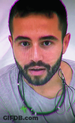 Man With Beard And Ear Buds Looking At Camera GIF