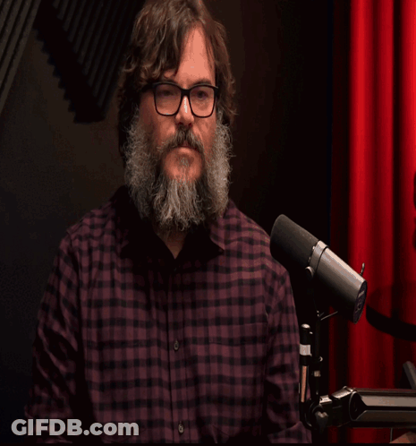 Man With Beard And Glasses At Microphone Saying Shalom GIF