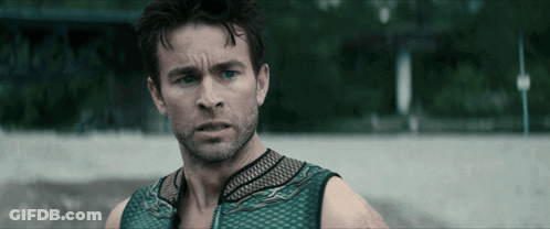 Man With Beard And Green Tank Top Looks At Camera GIF