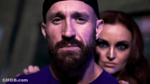 Man With Beard And Hat Standing Next To Woman In Dark Room GIF
