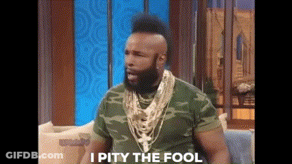 Man With Beard And Mohawk Sitting On Couch In Camo Shirt And Gold Necklaces GIF