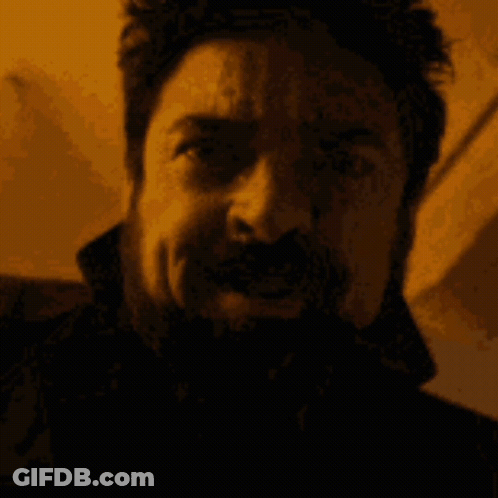 Man With Beard And Mustache Making Funny Face In Dark Room GIF