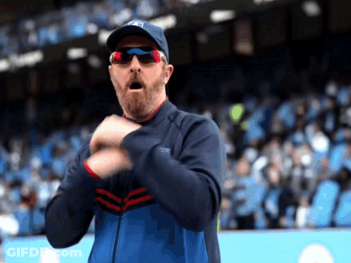 Man With Beard And Sunglasses Clapping In Stadium GIF