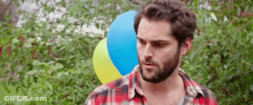 Man With Beard Holding Blue And Yellow Balloon GIF