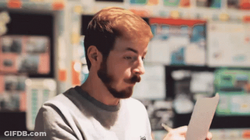 Man With Beard Holding Paper And Pen GIF