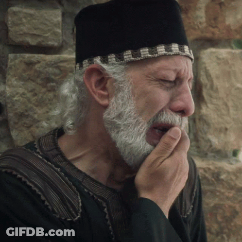 Man With Beard In Black Hat Covering Mouth GIF