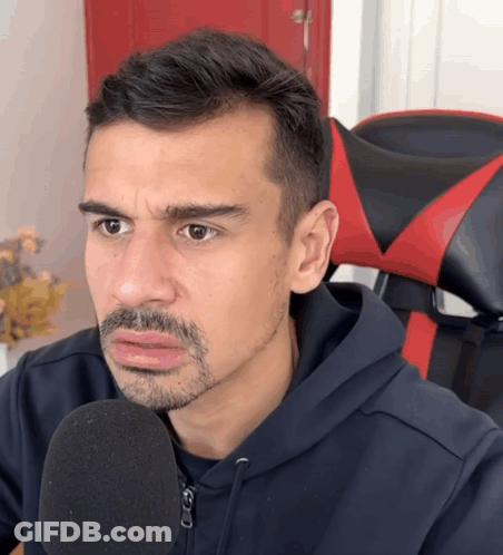 Man With Beard In Black Hoodie And Red Chair GIF