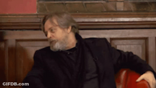 Man With Beard In Black Jacket Sitting In Red Chair GIF