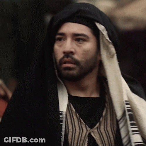 Man With Beard In Black Robe And Striped Vest GIF