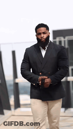 Man With Beard In Black Suit And Khaki Pants GIF