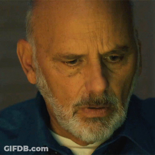 Man With Beard In Blue Shirt Looking Down GIF