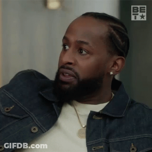 Man With Beard In Denim Jacket And Necklace Looking GIF
