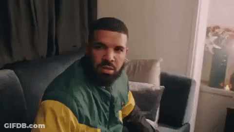 Man With Beard In Green And Yellow Jacket Sitting On Couch GIF