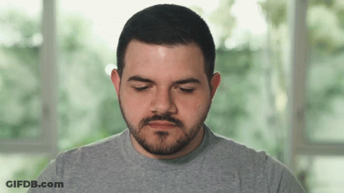 Man With Beard In Grey Shirt Looking Down GIF