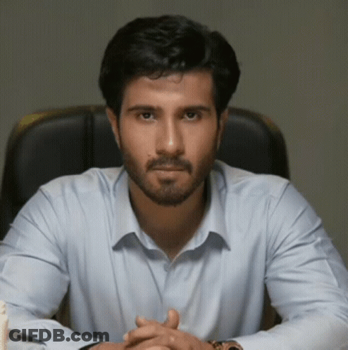 Man With Beard In Light Blue Shirt Sitting GIF