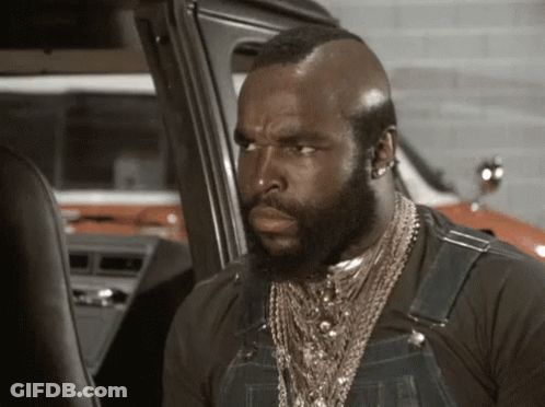 Man With Beard In Overalls And Necklace Next To Car GIF