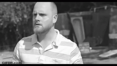 Man With Beard In Striped Shirt Looking At Camera GIF
