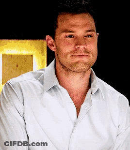 Man With Beard In White Shirt Looks At Camera GIF