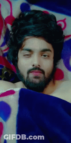 Man With Beard Laying Under Blue Blanket Eyes Closed GIF