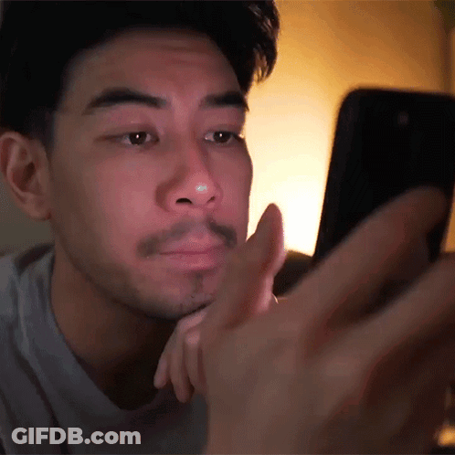 Man With Beard Looking At Cell Phone In Dark GIF