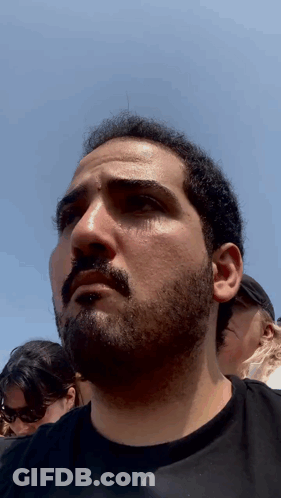 Man With Beard Looks At Camera GIF