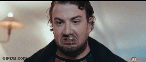 Man With Beard Making Funny Face With Glass In Mouth GIF