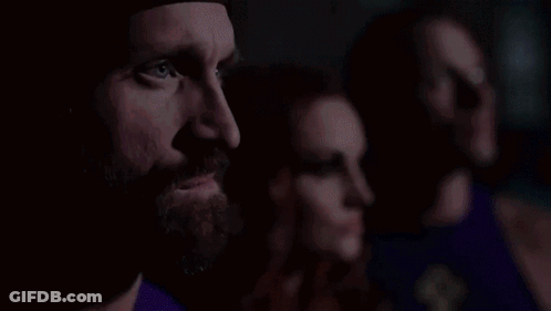 Man With Beard Next To Two Women In Purple Shirts GIF