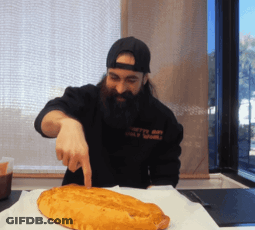 Man With Beard Pointing At Loaf Of Bread GIF