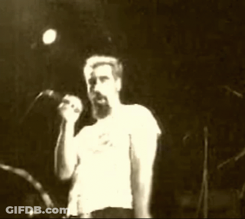 Man With Beard Singing Into Microphone On Stage GIF