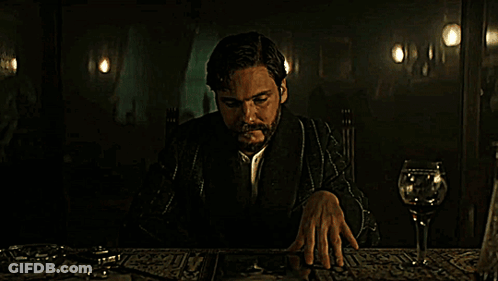 Man With Beard Sitting At Table With Wine Glass GIF