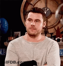 Man With Beard Sitting In Front Of Clock GIF