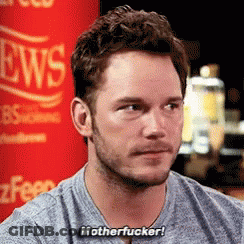 Man With Beard Sitting In Front Of Red News Sign GIF