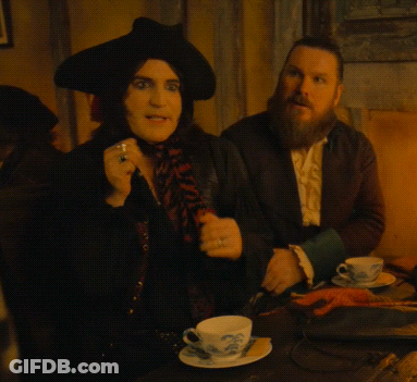 Man With Beard Sitting Next To Woman In Black Hat GIF